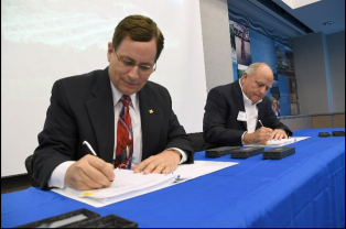 Philip W. Allin, Fairfax Water’s Chairman, and William “Kim” Duke, Vulcan’s Mideast Division President, sign the final documents for the official sale and purchase of a portion of Vulcan Materials land for the creation of a new reservoir in Lorton, Virginia, Oct. 25. (Photo courtesy of Fairfax Water)